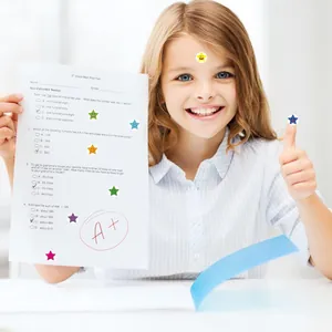 Close-up of smiley face star stickers on a school test paper for rewards