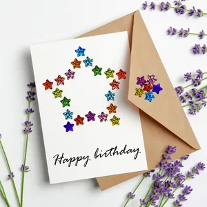 Holographic glitter star stickers decorating a white Happy Birthday greeting card.