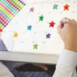 Colorful holographic star stickers with smiley faces used for calendar decoration and planning