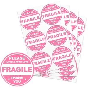 Close-up of pink round fragile warning stickers with handle with love and thank you text