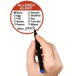 Primo piano di una mano che scrive su un'etichetta adesiva per allerta allergie