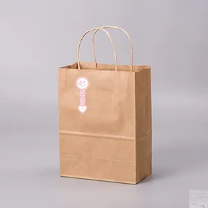 Pink smile face long strip sticker used as a seal on a brown kraft paper bag.