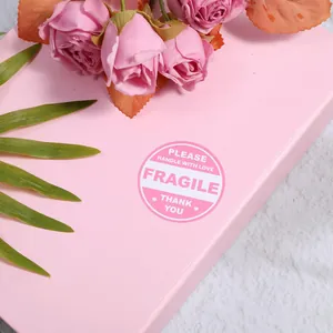 Close-up of pink Fragile warning sticker with Handle with Love text on gift box