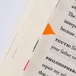 Dettaglio di un adesivo segnapagina arancione a forma di goccia su una pagina di libro