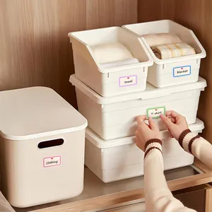 Close-up showing a colorful self-adhesive label being applied to a storage bin for organization
