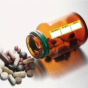 Yellow self-adhesive medication date labels on an amber pill bottle for record keeping