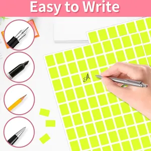 Primo piano di varie penne che scrivono su etichette adesive giallo neon brillanti