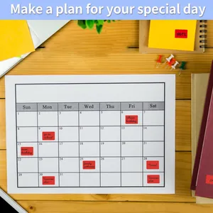 Piccole etichette adesive rosse impermeabili usate come indicatori su un calendario