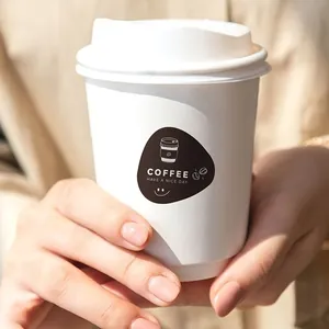 Close-up of a black 'HAVE A NICE DAY' coffee sticker on a white disposable cup.