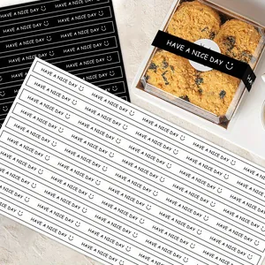 Close-up of black and white 'Have A Nice Day' sealing stickers for baking gift boxes