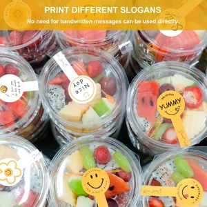 Close-up detail of yellow smiley face stickers used on fruit cups for decoration