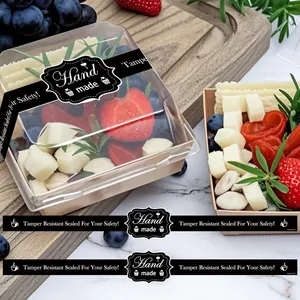 Black 'Hand Made' tamper-resistant sealing stickers applied to a fresh fruit box
