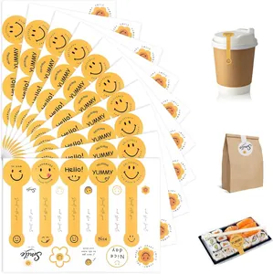 Collection of assorted yellow smiley face stickers for bakery packaging on white background
