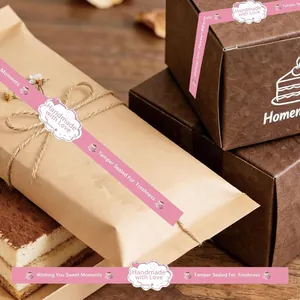 Detalle de pegatinas rosas hechas a mano en bolsa de papel y caja de regalo