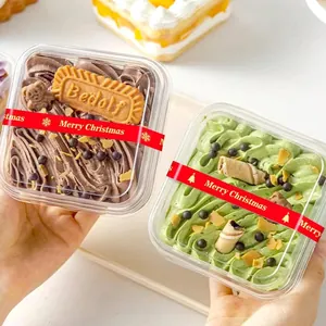 Detail of red Merry Christmas sealing stickers on transparent cake packaging boxes