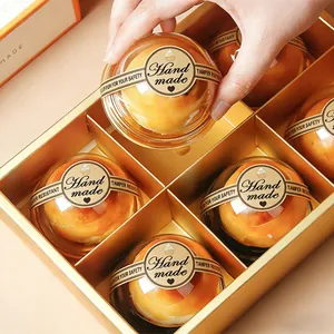 Dettaglio degli adesivi marroni 'Handmade' su confezioni per dolci