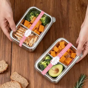 Detalle de las etiquetas adhesivas rosas "Handmade with Love" en recipientes de comida de inox.