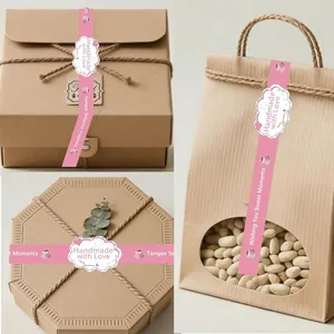 Pegatinas rosas 'Handmade with Love' aplicadas en varias cajas de regalo de papel kraft.