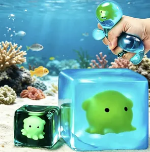 Macro detail of a hand squeezing a glowing blue underwater theme cube maltose squishy toy