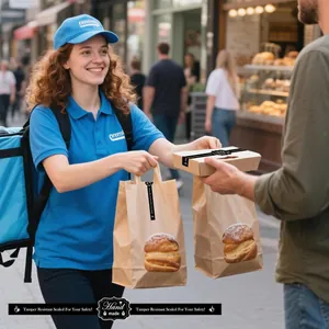 Detalle que muestra pegatinas de sello de seguridad en bolsas de papel para entrega de comida.