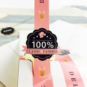 Primer plano de etiquetas adhesivas rosas de repostería con logo para empaque de regalo.