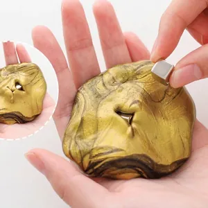 Pasta magnetica dorata giocattolo antistress con cubo magnetico tenuto in mano aperta