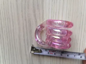 Gros plan d'un jouet antistress rose iridescent mesuré avec un ruban à mesurer précis.