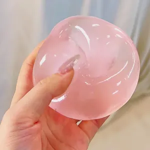 Detailed view of a pink translucent squishy stress relief ball with slow rebound texture