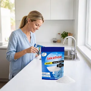 Woman pouring JAKEHOE instant drain cleaner powder into a sink in a modern kitchen