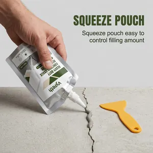 Heavy-duty concrete crack filler pouch being applied to a floor crack with a scraper