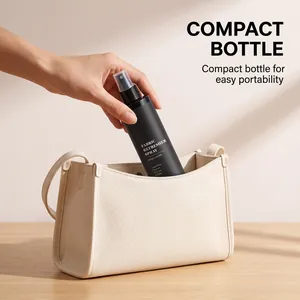 Hand placing black fabric refresher spray bottle into a beige cloth bag for easy travel.