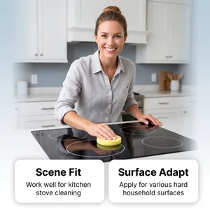 Close-up of a yellow sponge being used to clean a black glass stovetop in a kitchen setting