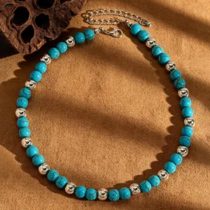 Detail view of a retro turquoise beaded necklace with silver metallic beads and textures