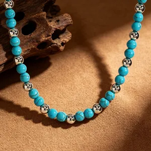 Close-up of vintage turquoise and silver bead necklace on natural desert sand texture