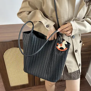 Vista dettagliata di una grande borsa tote intrecciata nera con un outfit casual elegante