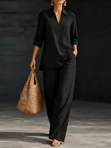 Elegante completo nero da donna con top a maniche lunghe con scollo a V e pantaloni.