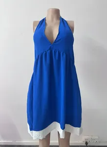 Robe dos nu bleue à col en V avec ourlet blanc sur un mannequin pour les vacances