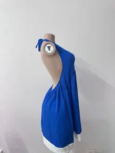 Vue latérale d'une robe de plage dos nu bleue en coton et lin avec ourlet blanc contrasté.