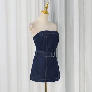 Side view detail of a dark blue denim strapless tube top with a matching belt on a mannequin.