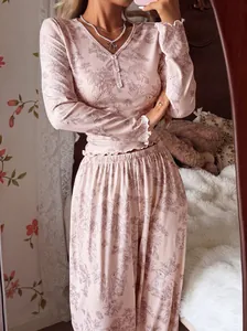 Dettaglio di un set pigiama a fiori rosa con elegante scollo a V e bottoni.