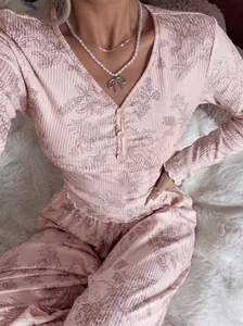 Elegante set pigiama a coste con stampa floreale rosa, maniche lunghe e orlo a volant