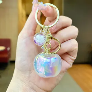 Beautiful iridescent white apple keychain with golden ring and glitter ball charm for bag
