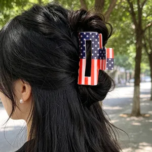 Close-up van een rechthoekige haarklem met Amerikaans vlagpatroon gestyled op donker haar.