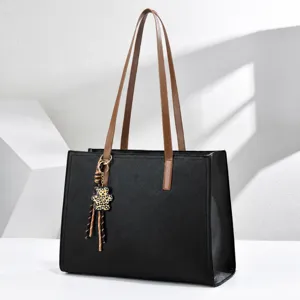 Bolso tote de cuero negro para portátil con asas marrones y colgante de oso leopardo