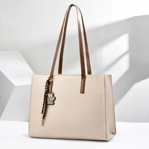 Bolso tote grande de cuero beige para portátil con correas marrones y colgante de osito