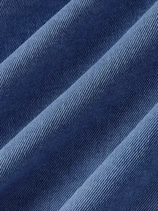 Primo piano del tessuto denim blu con trama a saia dettagliata e tessitura.
