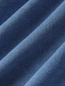 Primo piano macro della trama diagonale di alta qualità del tessuto denim blu per giacca