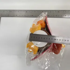 Detailed view of a glowing Thanksgiving turkey ornament being measured with a metal ruler.
