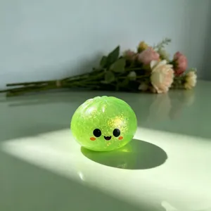 Primer plano de un simpático juguete blando tipo dumpling verde con purpurina interior