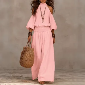 Detalle de conjunto rosa de dos piezas con top halter, hombros aire y pantalón ancho